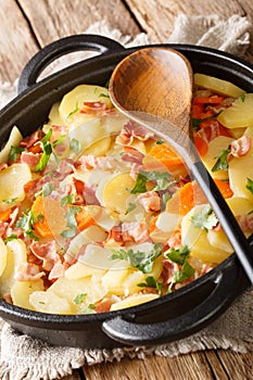 Tatws Pum MunudÂ is a traditional potato and bacon dish close-up in a pan. Vertical